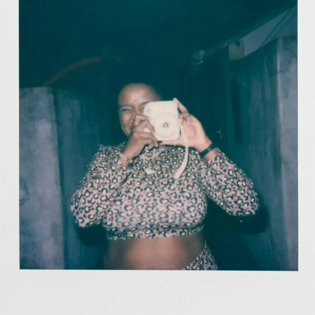 Image of a lady making a self portrait of themselves with an instant camera