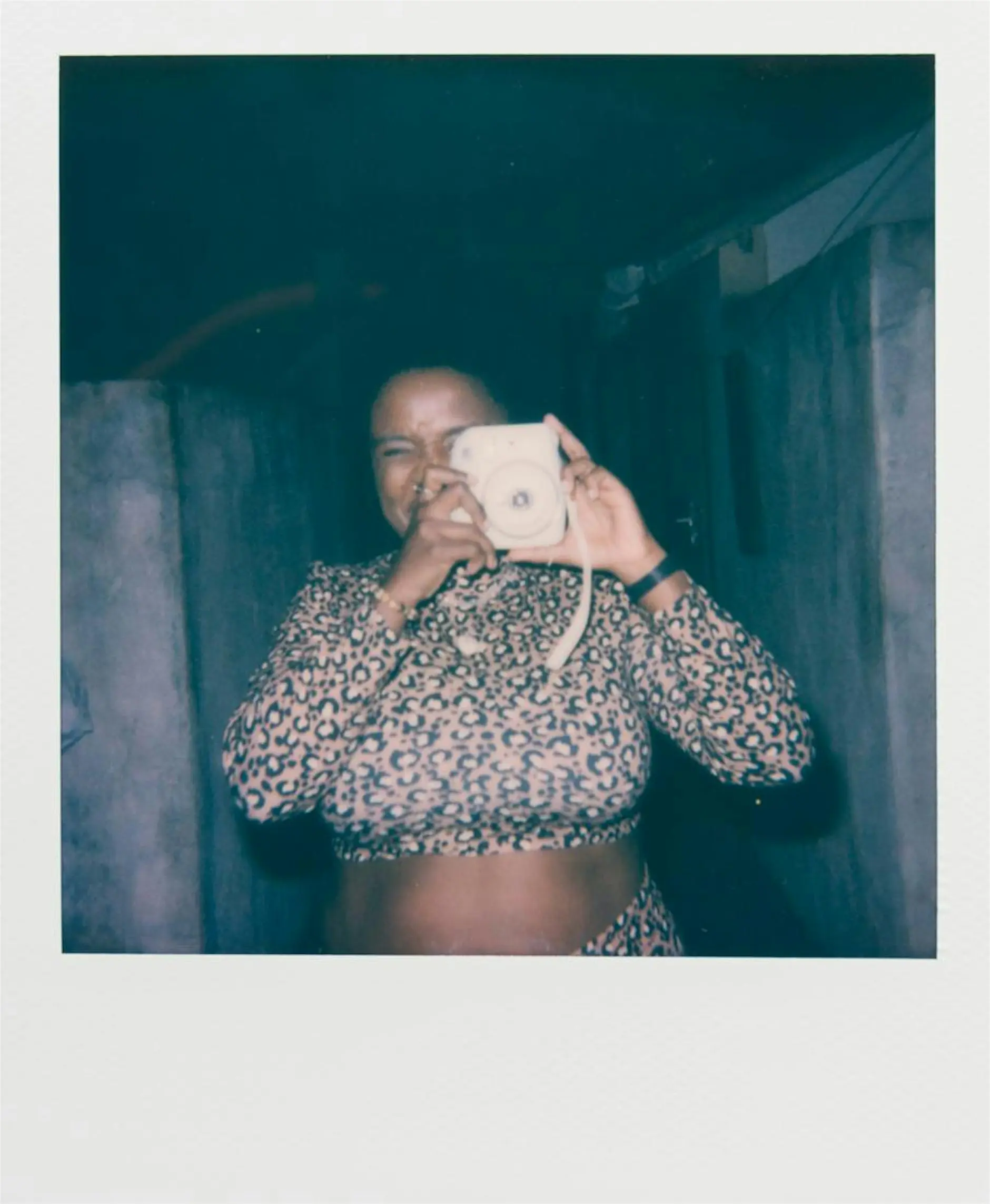 Image of a lady making a self portrait of themselves with an instant camera